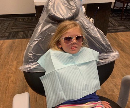 Little girl in dental chair before treatment