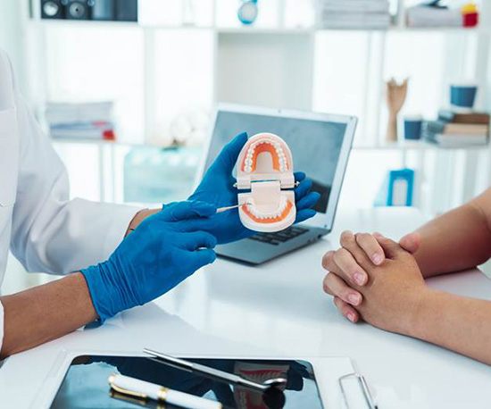 Dentist and patient sitting at desk during consultation