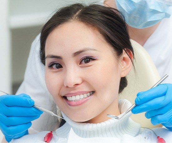 Smiling woman receiving dental exam