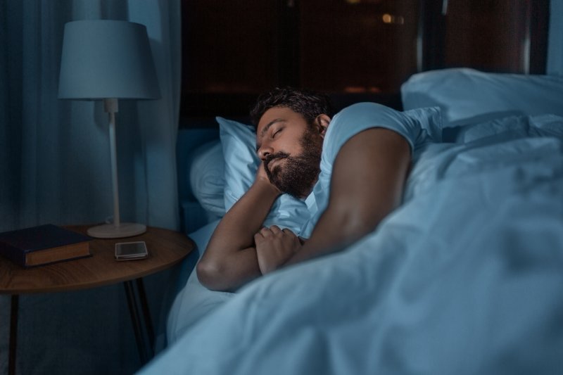 A man sleeping in bed at home at night